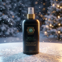 Bottle of 'Belle' 2-in-1 toiletries with a gold cap against a snowy background